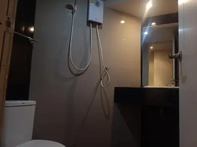 a bathroom with a shower and a toilet and a mirror at Arizona Residence in Ban Ko En