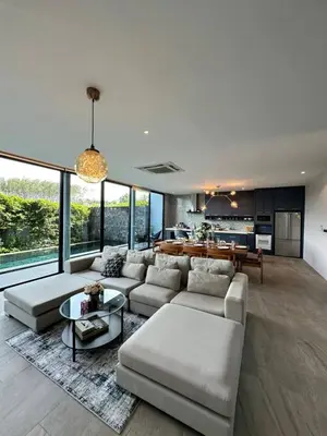 a living room with a couch and a table at Bangtao Family Villa with Pool in Ban Pak Lak