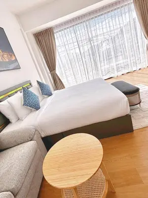 a bedroom with a bed and a couch and a table at Phuket gateway inn in Kathu