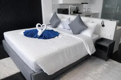 a large bed with two blue ruffles and a white ribbon at Новые апартаменты в Utopia Naiharn in Rawai Beach