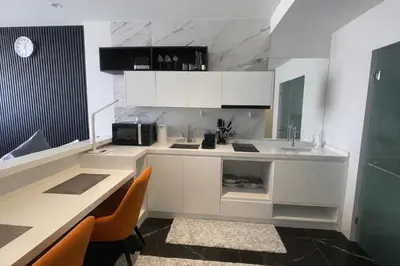 a kitchen with white cabinets and a sink and a counter at Новые апартаменты в Utopia Naiharn in Rawai Beach