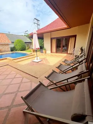a group of lounge chairs on a patio with a pool at Luxury 3-bedroom villa with pool in Rawai in Rawai Beach