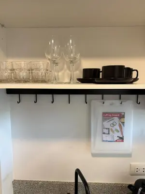a shelf with wine glasses and a plate on it at FAMILY HOMES Panoramic Pool View Studio in Mai Khao CB-706 in Ban Mai Salae