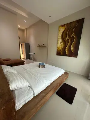 a bedroom with a large bed with a painting on the wall at Villa Bang Tao Ananda Lake View in Ban Pak Lak