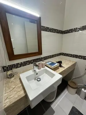 a bathroom with a white sink and a mirror at Villa Bang Tao Ananda Lake View in Ban Pak Lak