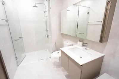 a white bathroom with a sink and a shower at Canvas 1112 TwoBedroom Residence in Phuket Town