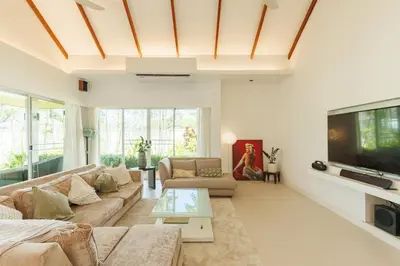 a living room with a couch and a tv at Peaceful Villa 12 mins to Bangtao & Layan Beach in Ban Pak Lak