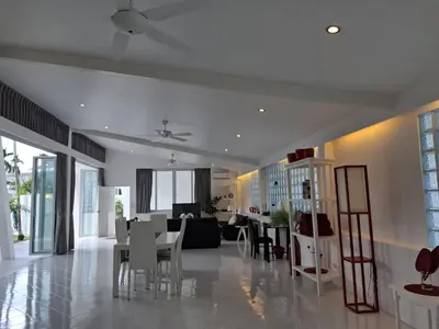 a dining room and living room with a table and chairs at Mango Villa in Ban Pa Khlok