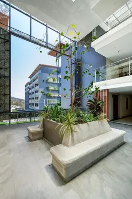 a lobby with a bench and plants in a building at Spacious studio with big patio ! in Rawai Beach