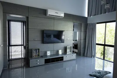 a living room with a television on a wall at Villa Wallaya with pool in Bang Tao in Ban Pak Lak