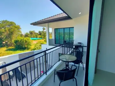 a balcony with a table and chairs and a view at Jitvirat Pool Villa in Ban Nong Chaeng