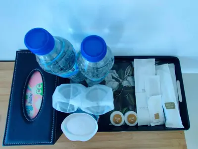 a container with water bottles and other items on a table at Jitvirat Pool Villa in Ban Nong Chaeng
