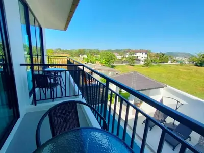 a balcony with chairs and a view of a yard at Jitvirat Pool Villa in Ban Nong Chaeng