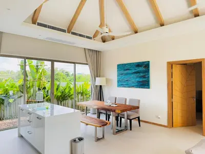 a kitchen and dining room with a table and chairs at Top Pick Brand New Modern Resort Pool Villa in Laguna Phuket