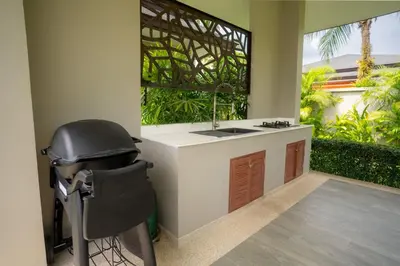 a bathroom with a sink and a chair next to a window at Beautiful Pool Villa in Pavilion and Tropical Oasis in Ban Pak Lak