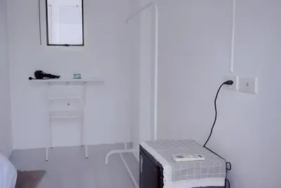 a white room with a bed and a mirror at BAO Phuket Patong- ไสน้ำเย็น ซอย 1 in Patong Beach