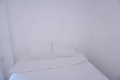a bed with white sheets on top of it at BAO Phuket Patong- ไสน้ำเย็น ซอย 1 in Patong Beach