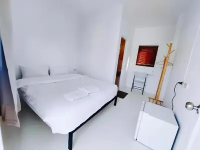 a white bedroom with a bed and a mirror at BAO Phuket Patong- ไสน้ำเย็น ซอย 1 in Patong Beach
