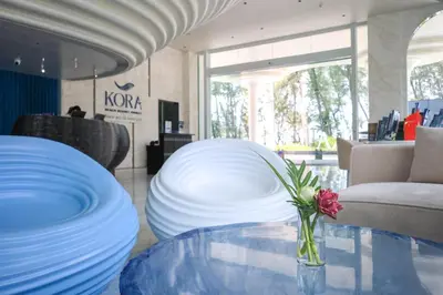 a table with white plates and a vase with a flower on it at The Sunshine Beach studio with a great view in Layan Beach