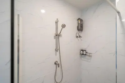 a shower in a bathroom with a phone on the wall at New Modern Escape Patong Poolvilla 2 mins to beach in Patong Beach