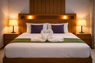 two swans shaped like hearts are sitting on a bed at Aura Inn in Patong Beach