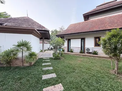 a house with a grass yard next to a house at ozone pool villa phuket in Ban Pa Khlok