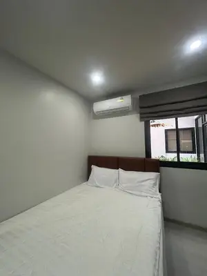 a small bedroom with a bed and a window at Hillside - Seashore Naiyang Beach in Phuket