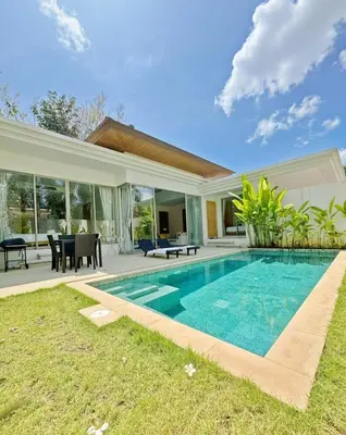 a villa with a swimming pool and a house at Trichada Tropical Private Tropical 3BR Pool Villa in Laguna Phuket