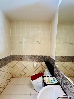 a bathroom with a tub and a toilet and a sink at Anda Beachside Hotel in Karon Beach
