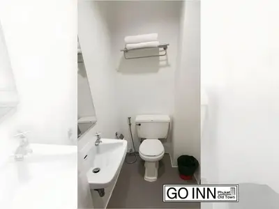 a white bathroom with a toilet and a sink at GO INN Phuket old Town in Ban Lo Long