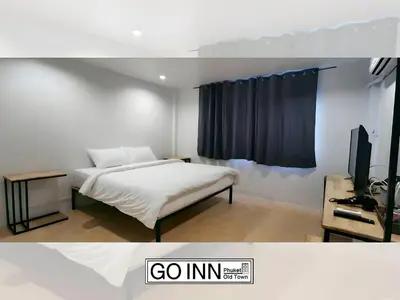 a bedroom with a bed and a tv in a room at GO INN Phuket old Town in Ban Lo Long