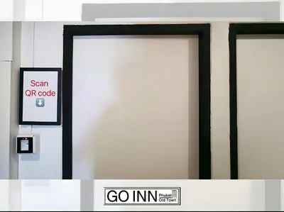 two white doors with black frames in a building at GO INN Phuket old Town in Ban Lo Long