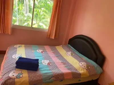 a bedroom with a bed with a quilt on it at Kittiya Mansion in Ban Phlu Nai