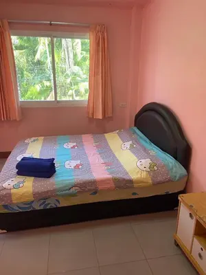 a small bedroom with a bed with a window at Kittiya Mansion in Ban Phlu Nai