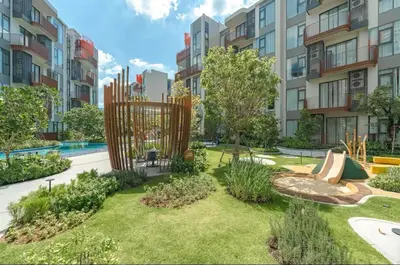 a garden with a playground in front of a building at Casa tua, luxury 2bed - Canvas by Sansiri in Laguna Phuket
