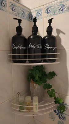 a shelf with two bottles of soap and a plant at Aonang room rent in Ban Khlong Haeng