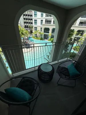 a balcony with two chairs and a view of a pool at Legendary D202 - The Title Legendary Bangtao Beach by UNO in Bang Tao Beach
