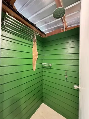 a room with green walls and a door with a towel at The Tent Naiyang in Nai Yang Beach