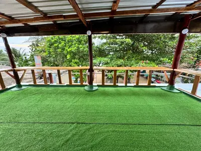a covered porch with green grass on it at The Tent Naiyang in Nai Yang Beach