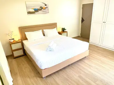 a bedroom with a large bed with white sheets at Top hotel in Patong Beach