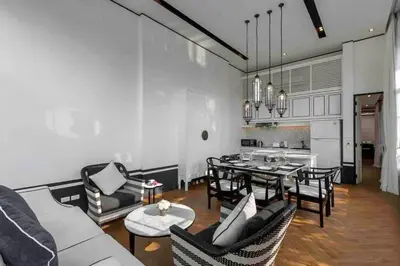 a living room with a table and chairs and a kitchen at Mono Villas Pasak - Three Bedroom Pool Villa in Bangtao in Ban Pak Lak