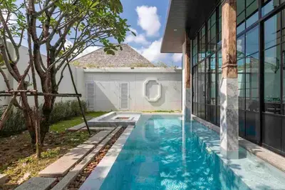 a swimming pool in front of a house at Mono Villas Pasak - Three Bedroom Pool Villa in Bangtao in Ban Pak Lak