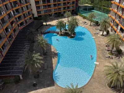 an overhead view of a large swimming pool with palm trees at 777 Beach Condo in Ban Mai Salae