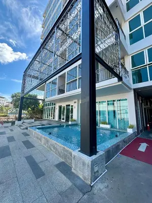 a building with a swimming pool in front of a building at Phuket Kata Studio Apartment in Kata Beach