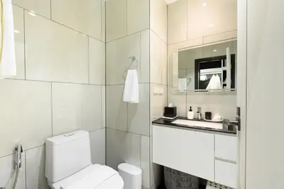 a white bathroom with a toilet and a sink at Bangtao Premium 2BR Apartment, Title Legendary B201 in Bang Tao Beach