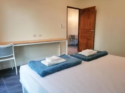 a bedroom with two beds with towels on top of it at TwinVillaSky in Ban Muang Mai