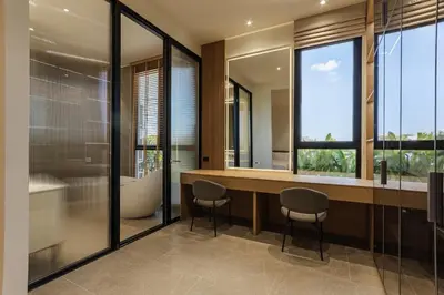 a bathroom with a tub and a sink and two chairs at PRAIA Residence 4BR - Bangtao in Ban Pak Lak