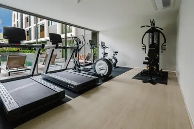 a gym with two treadmills and two exercise bikes at 1BR Ozon BangTao apartment in Laguna Phuket