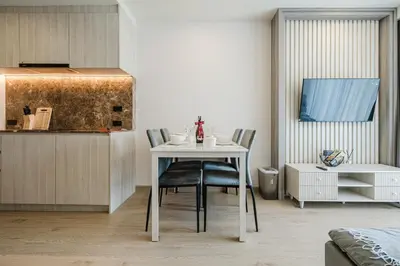 a dining room with a white table and chairs at 1BR Ozon BangTao apartment in Laguna Phuket