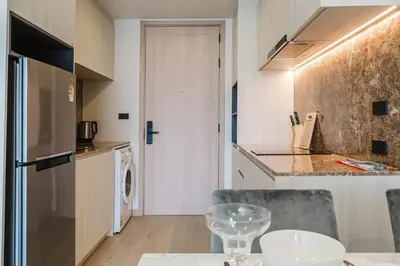 a kitchen with a dining table and a kitchen with a refrigerator at 1BR Ozon BangTao apartment in Laguna Phuket
